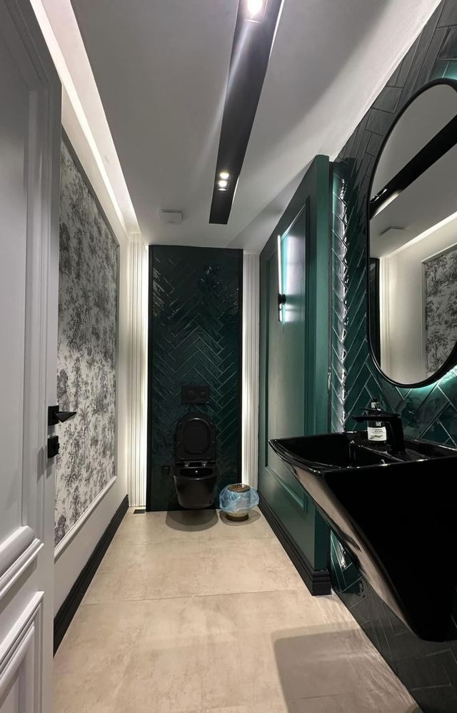 Koyu yeşil balıksırtı karolu, siyah lavabolu ve yuvarlak aynalı misafir WC